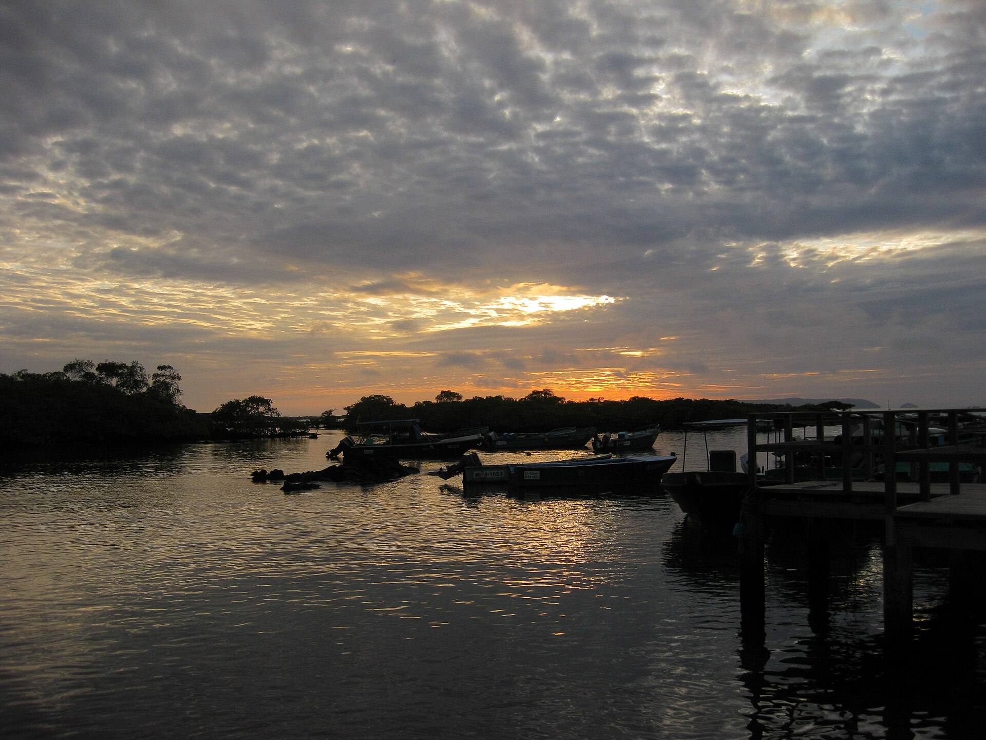 Small boats at the Puerto Villamil landing area in sunset light